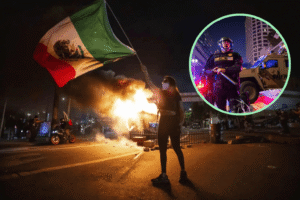 A protester waves a Mexican flag amid fires and chaos on a city street at night, with an inset image showing a heavily armed police officer responding to the unrest.